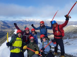 group of people on aummit of mountain on an alpine consolidation trip