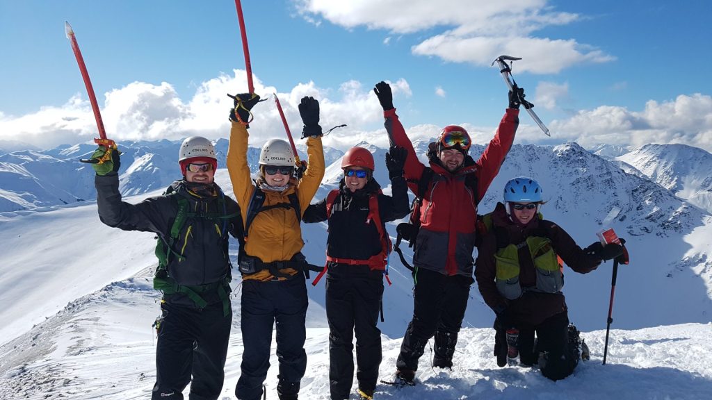 Mountaineers at the summit of a snowy peak