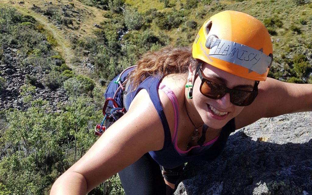 woman lead climbing on a rock